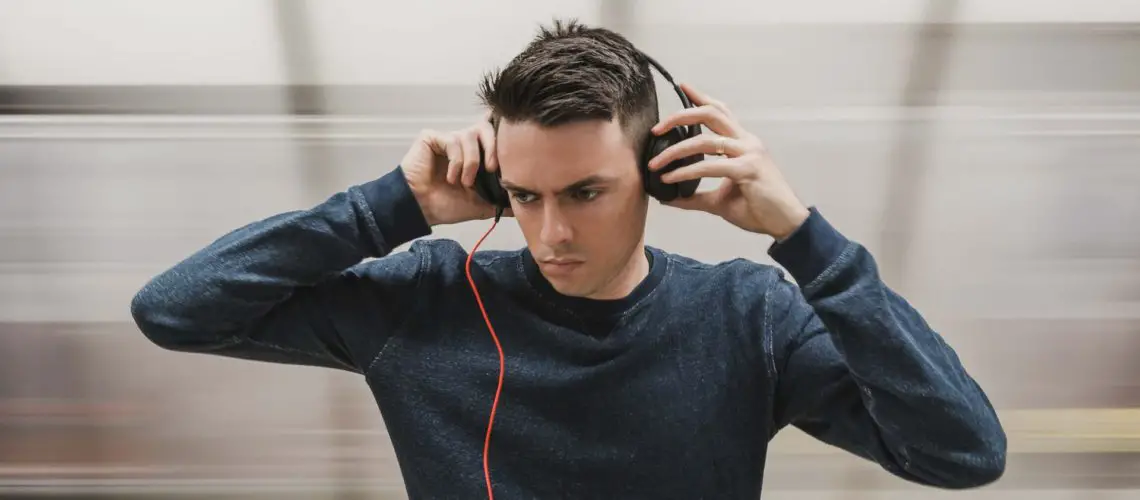 A man wearing cheap headphones wondering if they can damage his ears