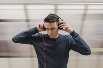 A man wearing cheap headphones wondering if they can damage his ears