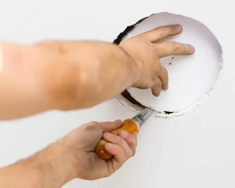 Cutting the drywall to install an in-ceiling speaker backbox